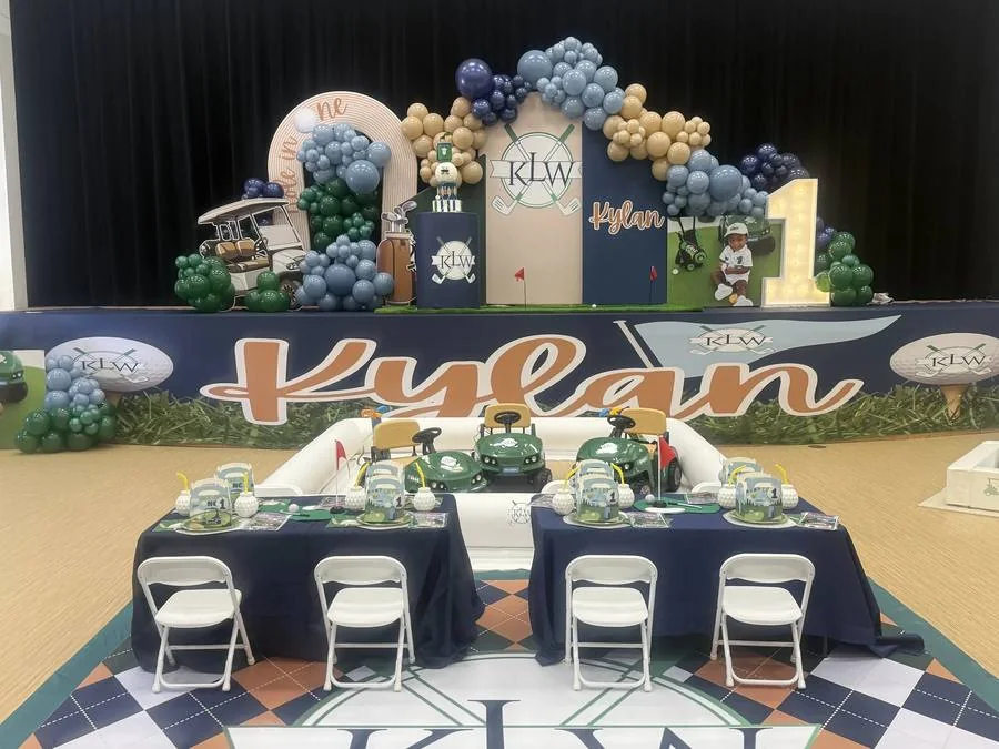 Blue and neutral balloon backdrop with styled tables