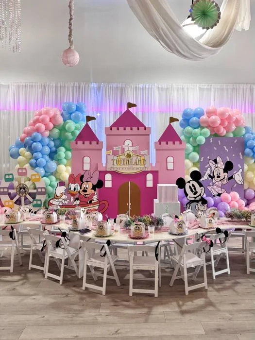 Pink castle birthday backdrop with pastel balloons and party tables